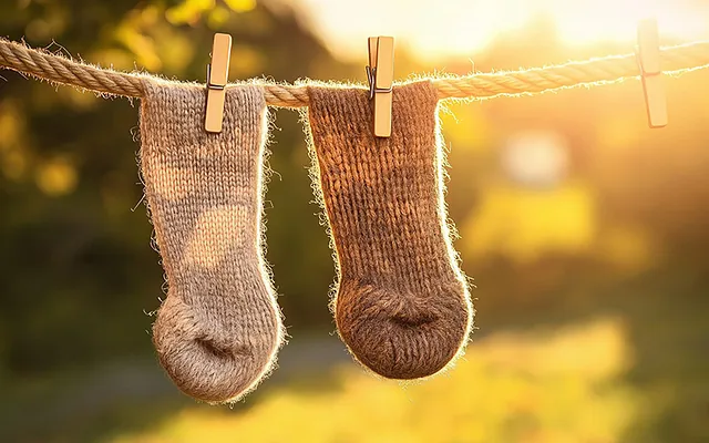 Braune Socken trocknen nach einem Wasserschaden draußen.